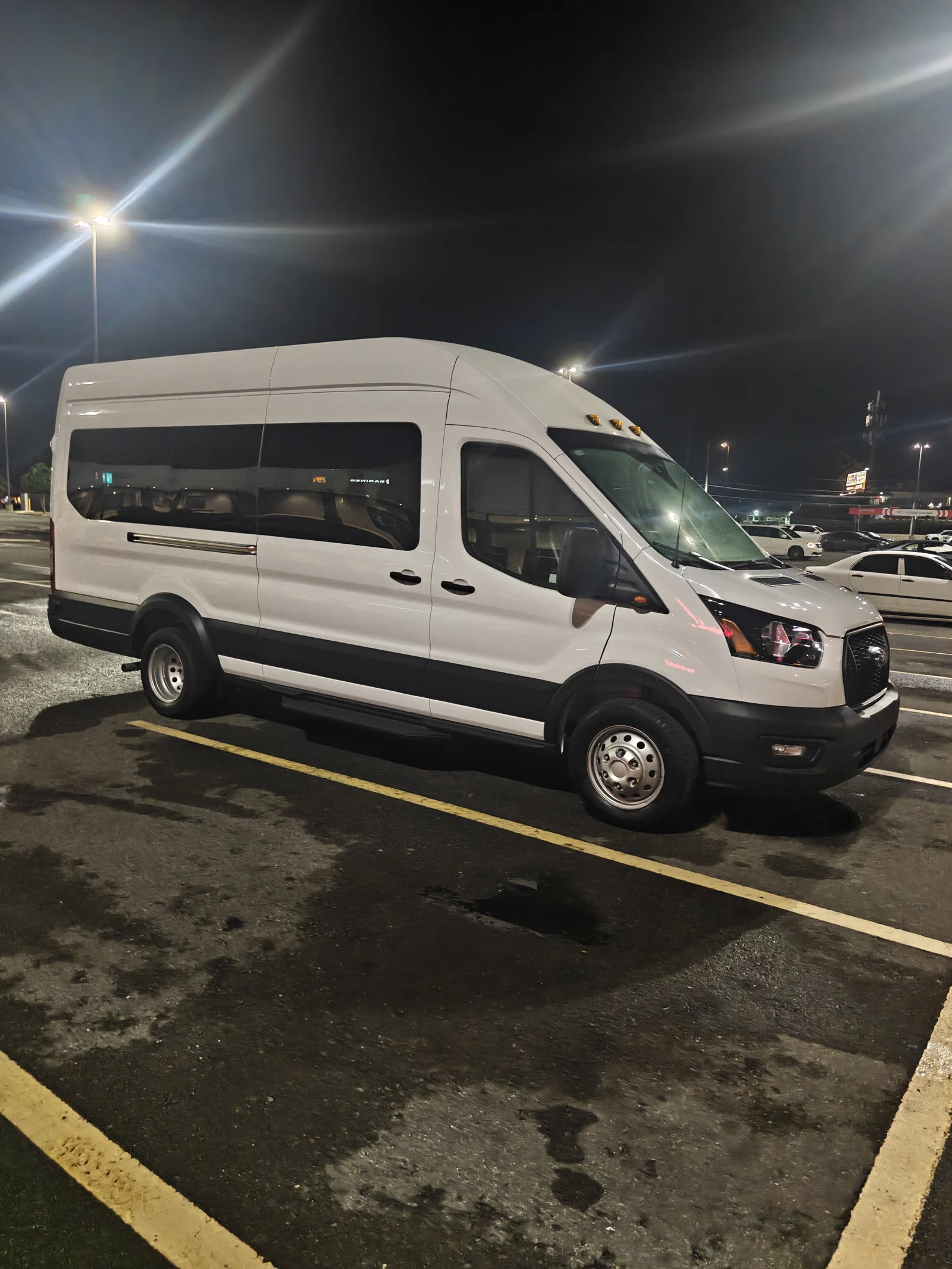 White high-roof Ford Transit passenger van with full passenger windows